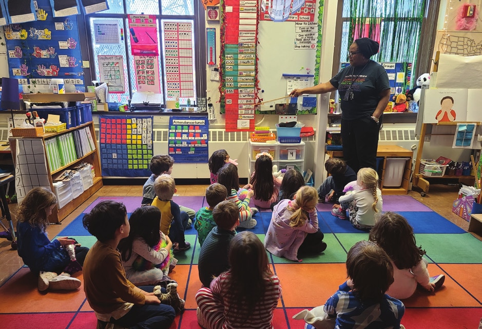 A McGilvra teacher leads a lesson with students gathered on the classroom rug.