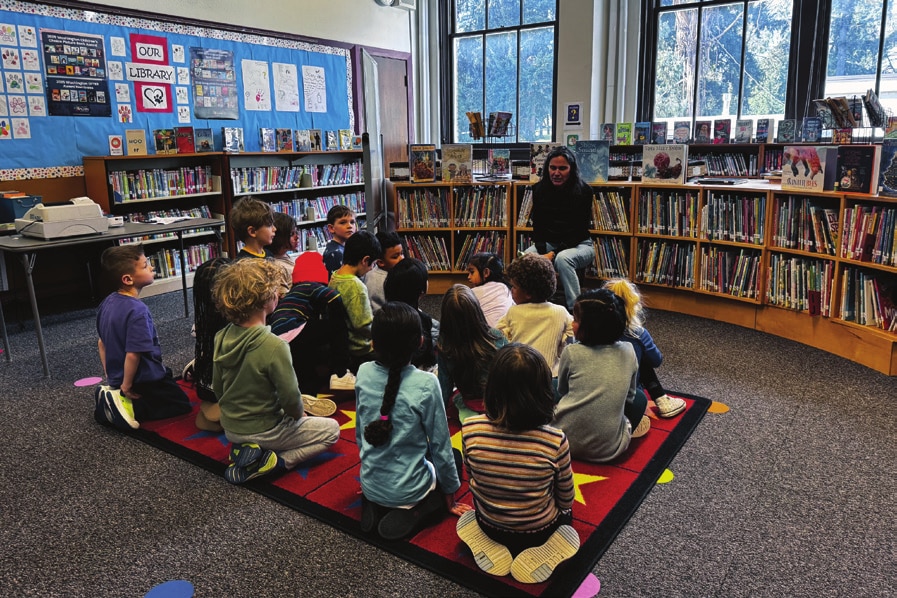 Students gathered with the school librarian among the bookshelves in McGilvra’s library.